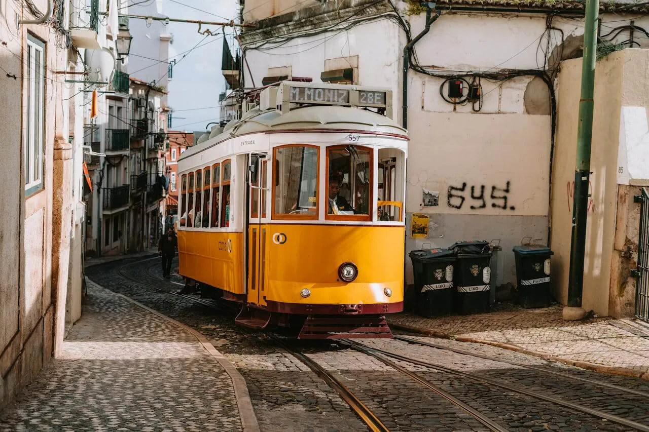 A yellow tram on a street in Lisbon