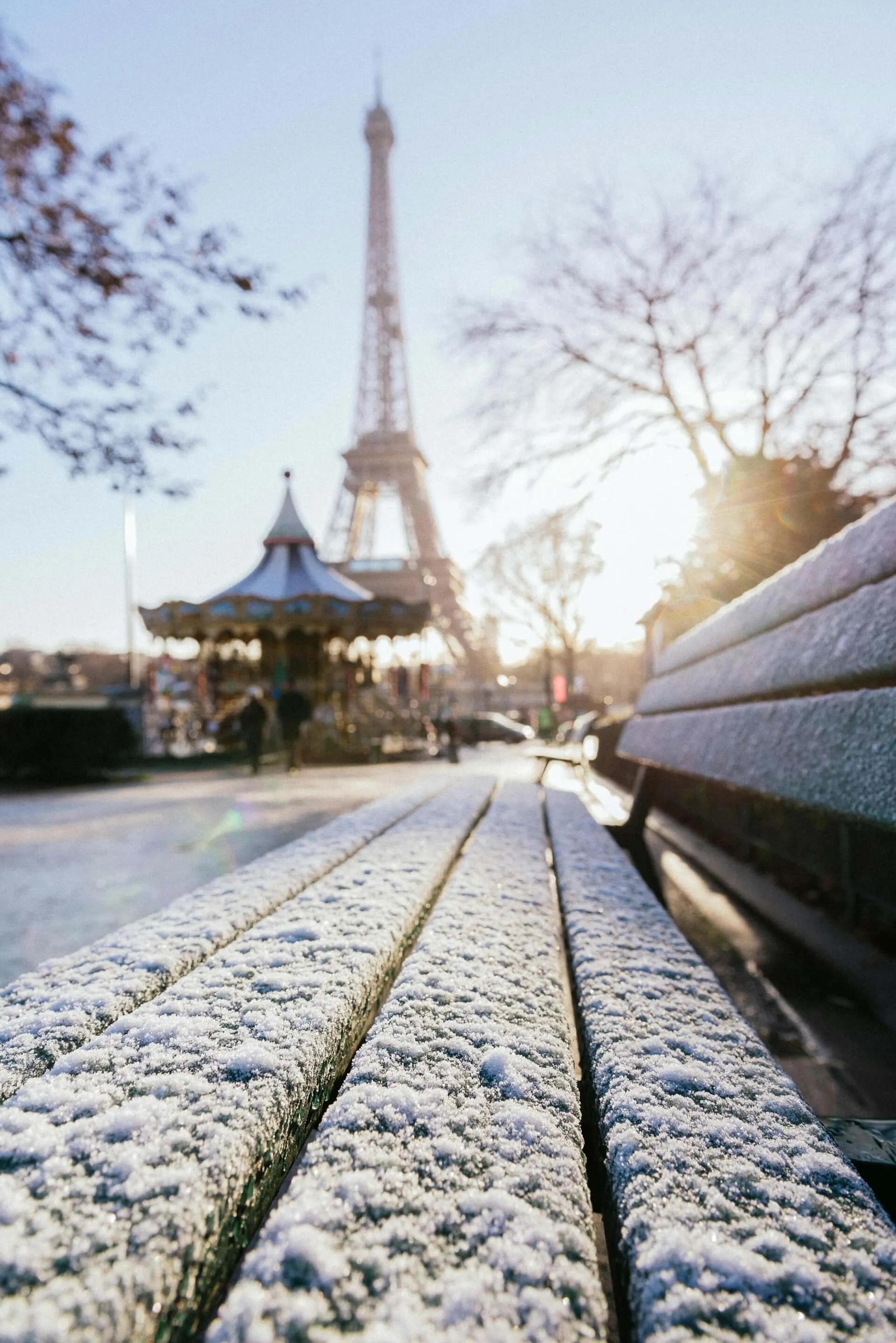 The eifel torwe vieved from a bench with snow