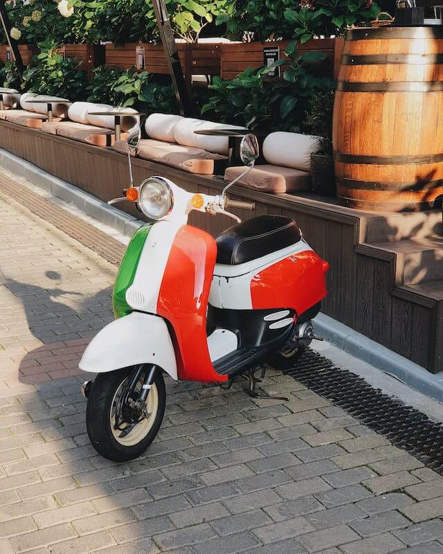 A Vespa motorbike with the colors of the Italian flag
