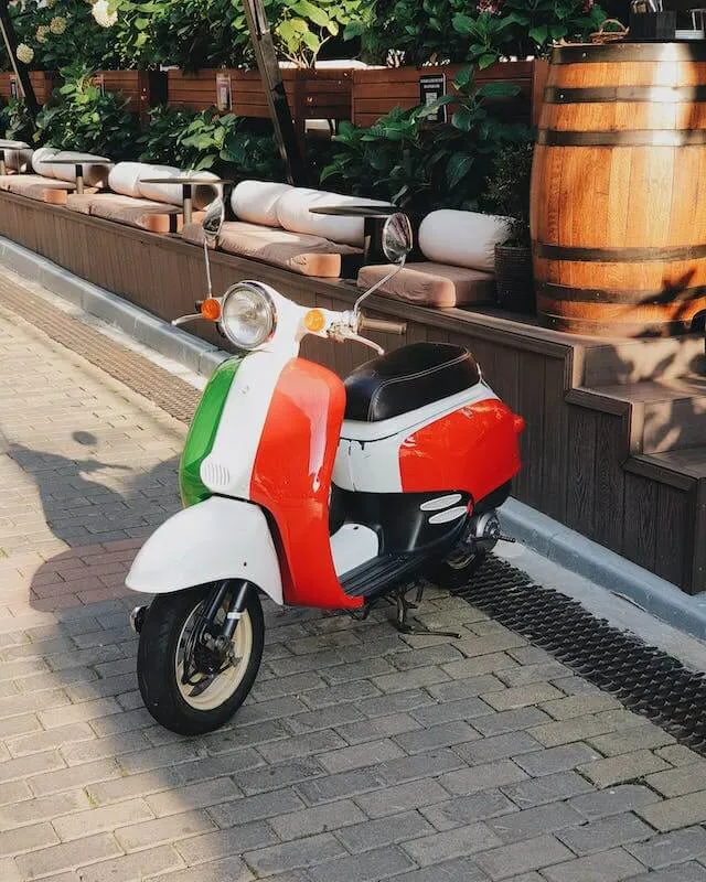A Vespa motorbike with the colors of the Italian flag