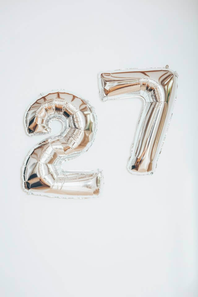 Two silver balloons with the shape of a two and a seven