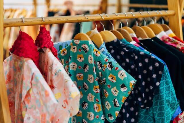 Many pieces of clothes hanging on a wardrobe