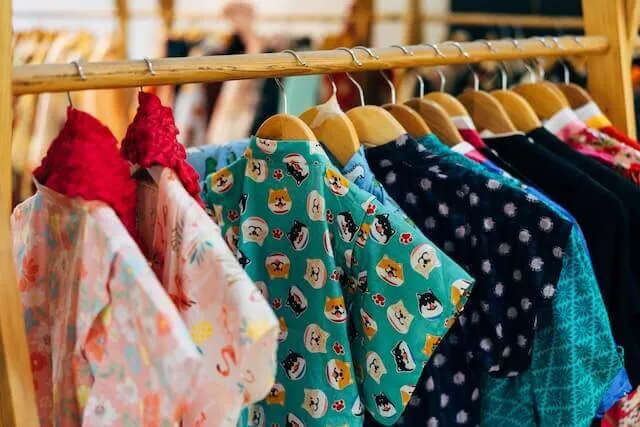 Many pieces of clothes hanging on a wardrobe