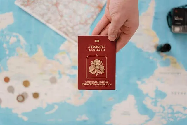 A man holding a passport over a world map